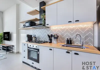 a kitchen with white cabinets and a wooden counter top at Stunning 1bed In Dubai Hills in Dubai