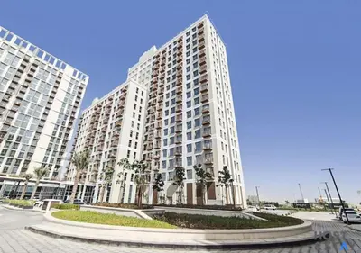 a large apartment building with palm trees in front of it at Stunning 1bed In Dubai Hills in Dubai