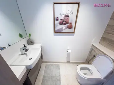 a white bathroom with a toilet and a sink at #140 Elegant 1BR with Burj Khalifa View in Business Bay in Dubai