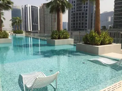 a swimming pool with two chairs on a building at #140 Elegant 1BR with Burj Khalifa View in Business Bay in Dubai