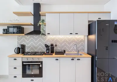 a kitchen with white cabinets and a black refrigerator at Elegant 1BR In Collective, Dubai Hills in Dubai