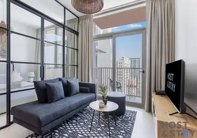 a living room with a couch and a large window at Elegant 1BR In Collective, Dubai Hills in Dubai