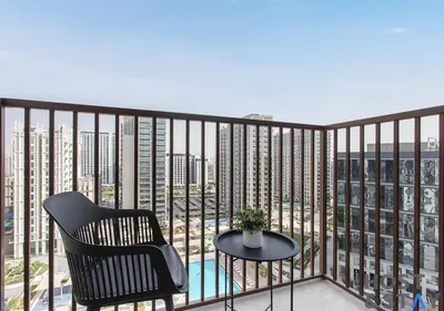 a balcony with a chair and a table with a view at Amazing 1BR in Collective2, Dubai Hills in Dubai