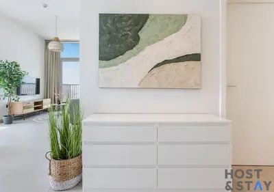 a living room with white furniture and a painting on the wall at Modern 2BR Gem In Dubai Hills in Dubai