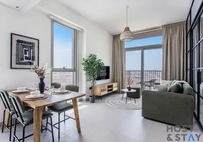a living room with a table and a couch at Modern 2BR Gem In Dubai Hills in Dubai