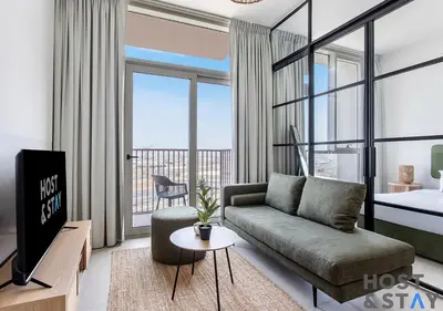 a living room with a couch and a tv at Serene 1BR Getaway In Collective in Dubai