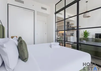 a bedroom with a white bed and a large window at Serene 1BR Getaway In Collective in Dubai