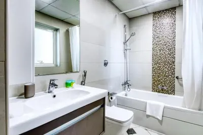 a bathroom with a sink and a toilet and a tub at ShoresInn - Spacious unit with Dubai Marina View in Dubai