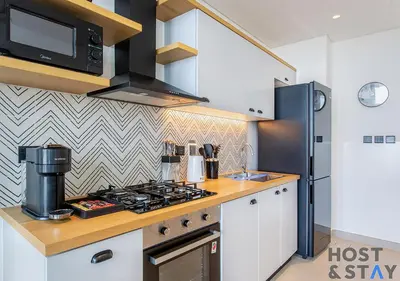 a kitchen with a stove and a microwave at Stylish 1BR Apt In Collective 2 in Dubai