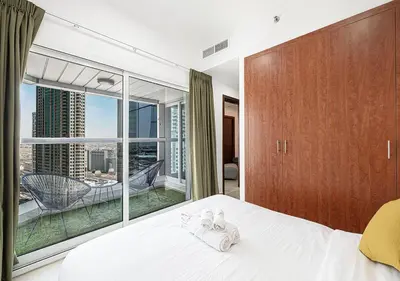 a bedroom with a white bed and a large window at Luxury home with stunning view in Dubai