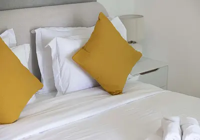 a white bed with two yellow pillows on it at Luxury home with stunning view in Dubai