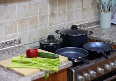 a cutting board with a tomato and green vegetables on a stove at Luxury home with stunning view in Dubai