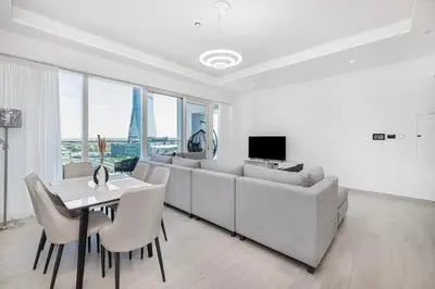 a living room with a couch and a table with chairs at Medore Brand New Flat in Dubai - 8 in Dubai