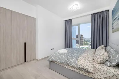 a bedroom with a bed and a large window at Medore Entire Brand New Flat in Dubai in Dubai