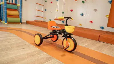 an orange bike in a room with a playground at Medore High Floor Brand New Apartment - 27 in Dubai