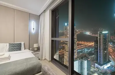 a bedroom with a view of a city at night at Burj View Infinity Pool - Dubai Mall Connection in Dubai