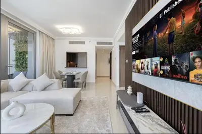 a living room with a couch and a movie poster on the wall at Burj View Infinity Pool - Dubai Mall Connection in Dubai