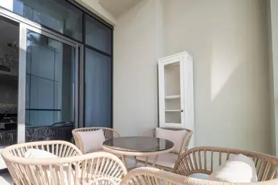 a patio with chairs and a table and a window at Aykon City 2 bedroom Burj view in Dubai