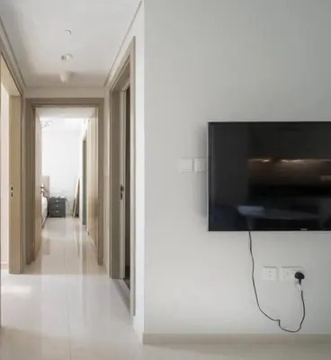 a flat screen tv hanging on a wall in a hallway at Aykon City 2 bedroom Burj view in Dubai
