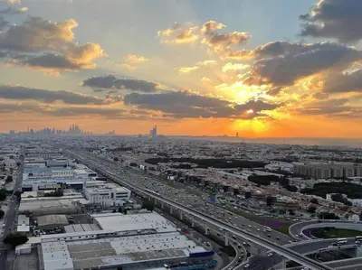 a view of a city with a highway at sunset at Aykon City 2 bedroom Burj view in Dubai