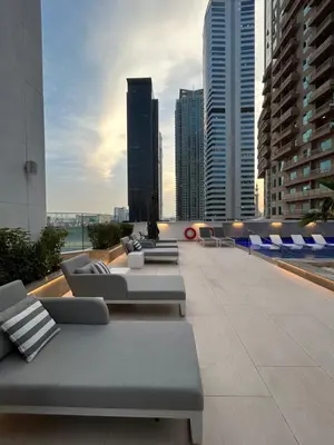 a rooftop patio with couches and chairs on a building at High Floor Brand New Apartment - 34 in Dubai