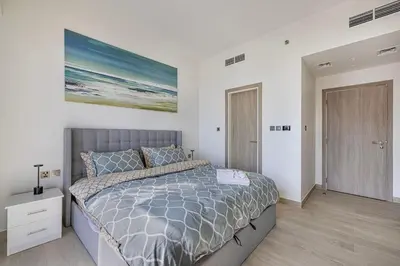 a bedroom with a bed and a painting on the wall at High Floor Brand New Apartment - 34 in Dubai