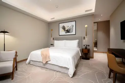 a bedroom with a large white bed and a desk at Address Emaar Flagship Burj Khalifa Fountain view UPSCALE in Dubai