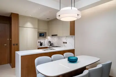 a kitchen with a white table and chairs at Address Emaar Flagship Burj Khalifa Fountain view UPSCALE in Dubai