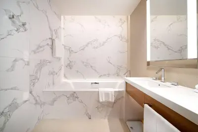 a white bathroom with a tub and a sink at Address Emaar Flagship Burj Khalifa Fountain view UPSCALE in Dubai