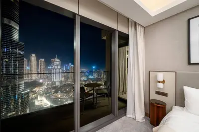 a bedroom with a view of a city at night at Address Emaar Flagship Burj Khalifa Fountain view UPSCALE in Dubai