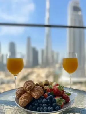 a plate of fruit and nuts and two glasses of orange juice at Luxury - Fountain Show & Burj Khalifa View - 2 BR - 3 beds in Dubai