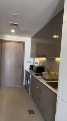 a kitchen with stainless steel appliances and a wooden door at Lovely Studio, Azizi Riviera in Dubai