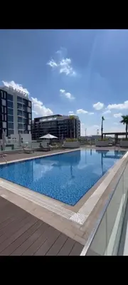 a large swimming pool in front of a building at Lovely Studio, Azizi Riviera in Dubai