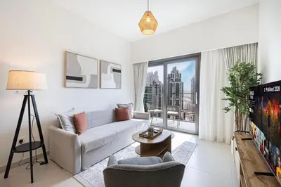 a living room with a couch and a tv at Luxury Minimalistic Apartment in Downtown Dubai Opposite Burj Khalifa & Dubai Mall in Dubai