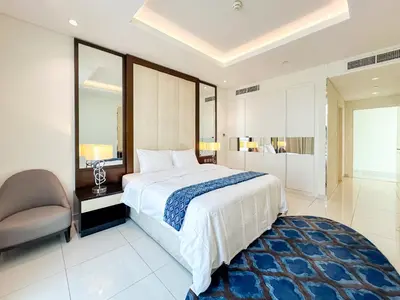a bedroom with a large bed and a chair at Panoramic Burj Khalifa View Luxury 1BR Penthouse in Dubai