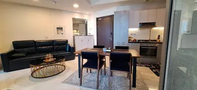 a living room with a table and a black couch at Bayz by Danube Marasi Drive in Dubai