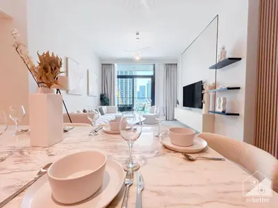 a dining room with a table with plates and wine glasses at Luxury Burj Crown Downtown Balcony & View in Dubai