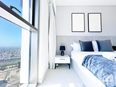 a white bedroom with a bed and a window at Luxury Burj Crown Downtown Balcony & View in Dubai