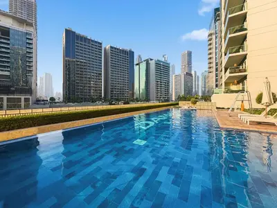 a large swimming pool in a city with tall buildings at Stunning Canal Views l Sleeps 6 in Dubai