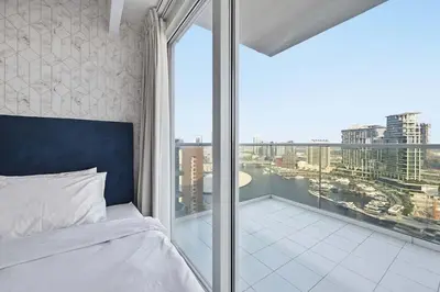 a bedroom with a bed and a large window at Stunning Canal Views l Sleeps 6 in Dubai