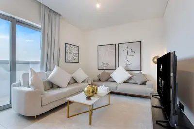 a living room with a white couch and a tv at STAY BY LATINEM Luxury 2BR Holiday Home CVR B1705 near Burj Khalifa in Dubai