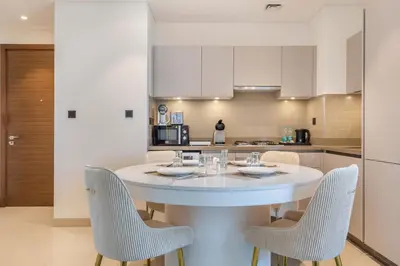 a kitchen with a white table and chairs at STAY BY LATINEM Luxury 2BR Holiday Home CVR B1705 near Burj Khalifa in Dubai