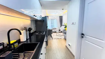 a kitchen with a sink and a living room at Dubai Marina - Modern Classic Studio Apartment in Dubai