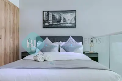 a bedroom with a white bed with towels on it at Bloomfields Cozy 1br Townhouse Life Style City in Nadd Shubayḩ