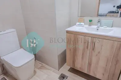 a bathroom with a white toilet and a sink at Bloomfields Cozy 1br Townhouse Life Style City in Nadd Shubayḩ