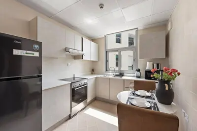 a kitchen with a table and a black refrigerator at Studio -DEC Towers T2 - Near Marina Beach in Dubai