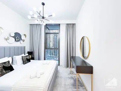 a white bedroom with a large bed and a desk at Stunning Burj Crown 2Bedroom with Balcony & view in Dubai