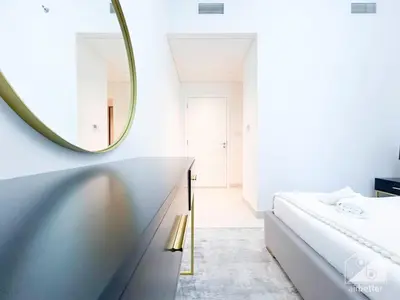 a white bedroom with a mirror and a bed at Stunning Burj Crown 2Bedroom with Balcony & view in Dubai