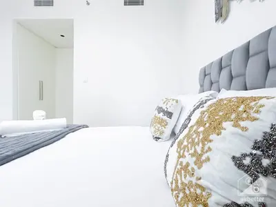 a bedroom with a bed with a gray headboard and pillows at Stunning Burj Crown 2Bedroom with Balcony & view in Dubai
