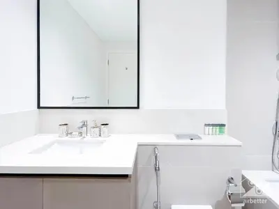 a white bathroom with a sink and a mirror at Stunning Burj Crown 2Bedroom with Balcony & view in Dubai